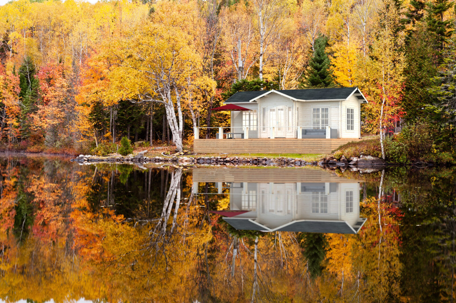 Reflections of a autumn forest and a house in a lake